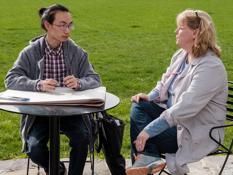 Student and professor discussing in the Perkins Plaza