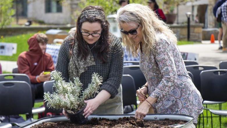 Berks staff member and student plant seeds in campus garden